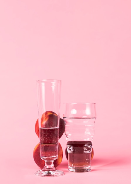 Frutas de nectarina y vasos llenos de agua