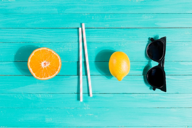 Frutas, pajitas y gafas de sol en orden.