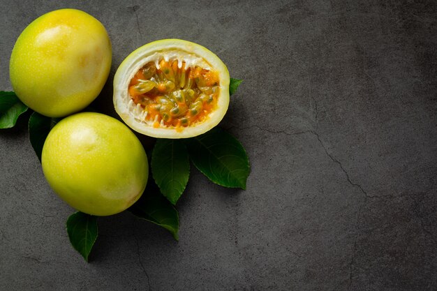 Frutas de la pasión frescas cortadas por la mitad en el piso oscuro