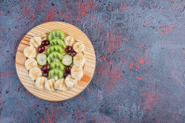 Frutas picadas y en rodajas en un plato de madera.