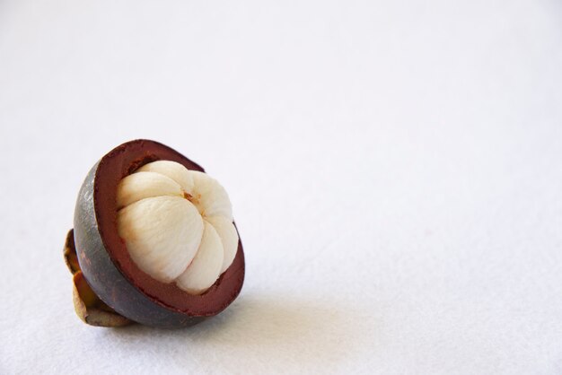 Frutas populares tailandesas del mangostán: una fruta tropical con segmentos de pulpa dulce y blanca dentro de una gruesa corteza de color marrón rojizo.