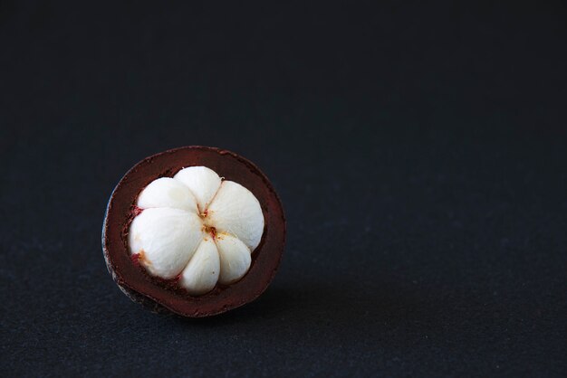 Frutas populares tailandesas del mangostán: una fruta tropical con segmentos de pulpa dulce y blanca dentro de una gruesa corteza de color marrón rojizo.