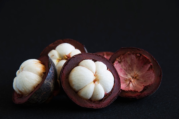 Frutas populares tailandesas del mangostán: una fruta tropical con segmentos de pulpa dulce y blanca dentro de una gruesa corteza de color marrón rojizo.