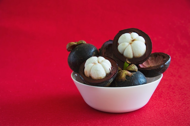 Frutas populares tailandesas del mangostán: una fruta tropical con segmentos de pulpa dulce y blanca dentro de una gruesa corteza de color marrón rojizo.