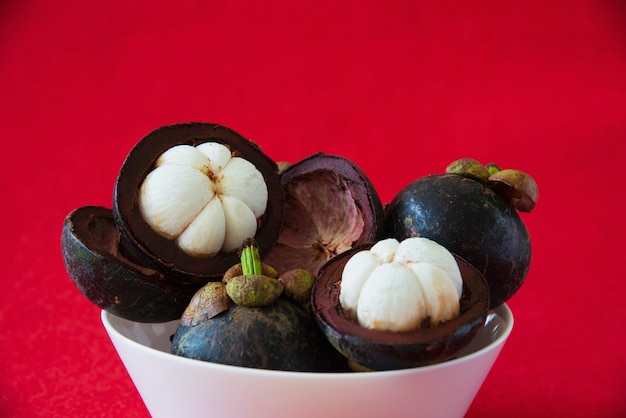 Frutas populares tailandesas del mangostán: una fruta tropical con segmentos de pulpa dulce y blanca dentro de una gruesa corteza de color marrón rojizo.