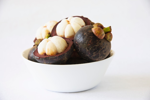 Frutas populares tailandesas del mangostán: una fruta tropical con segmentos de pulpa dulce y blanca dentro de una gruesa corteza de color marrón rojizo.