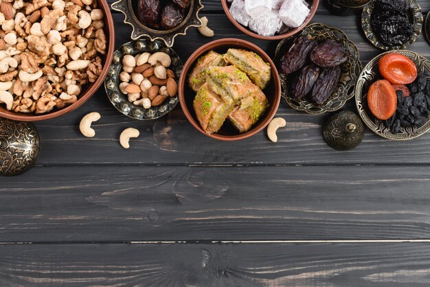 Frutas secas; nueces; fechas; Lukum y baklava en Ramadán sobre el escritorio de madera