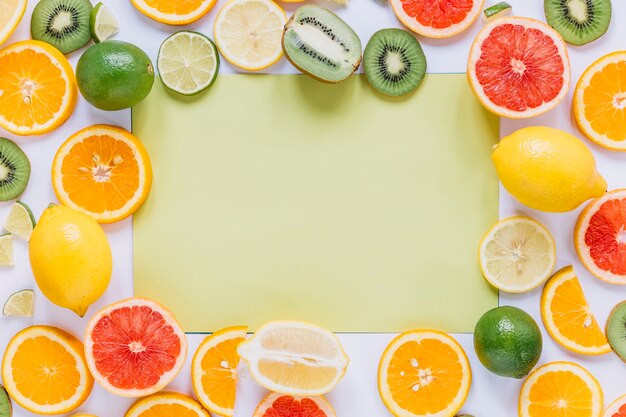 Frutas surtidas alrededor de la hoja de papel verde