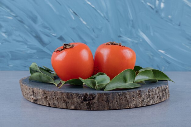 Frutas de temporada. Caqui sobre tabla de madera