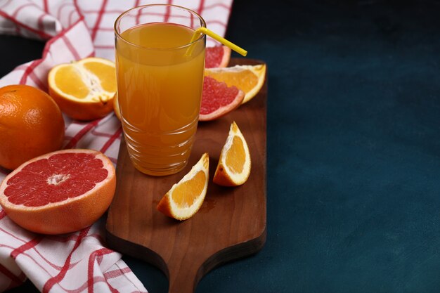 Frutas tropicales con un vaso de jugo de naranja.