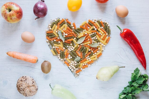 Frutas y verduras alrededor del corazón de pasta