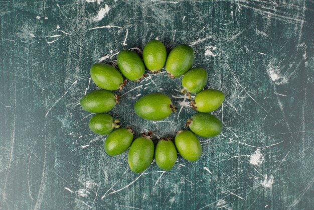 Frutos de feijoa verde sobre superficie de mármol.