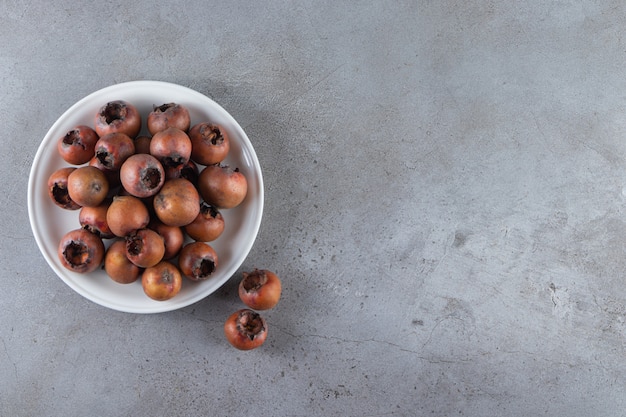 frutos de níspero maduros colocados sobre fondo de piedra.