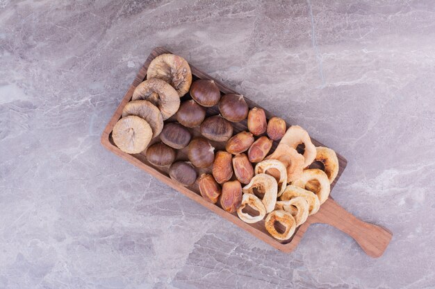 Frutos secos y bayas en un plato de madera.