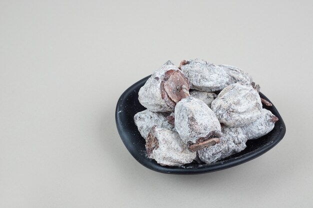 Frutos secos de caqui en tazón negro