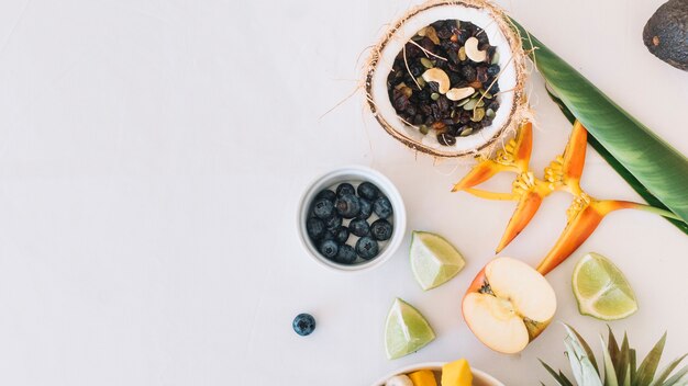 Frutos secos en el coco con flor de ave del paraíso sobre fondo blanco