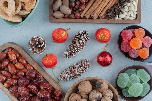 Frutos secos saludables en placa de madera con juguetes de Navidad. Foto de alta calidad