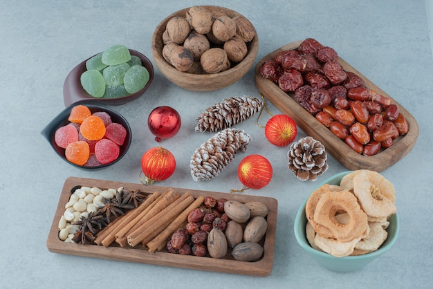 Frutos secos saludables en placa de madera con juguetes de Navidad. Foto de alta calidad