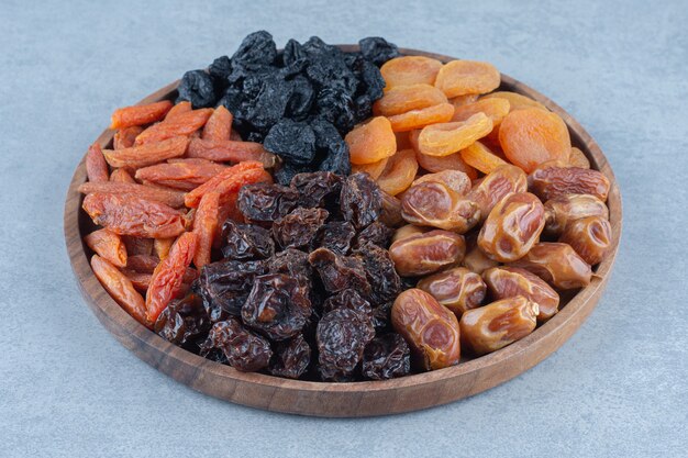 Frutos secos en la tabla de madera, sobre la mesa de mármol.