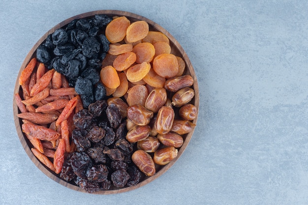 Frutos secos en la tabla de madera, sobre la mesa de mármol.