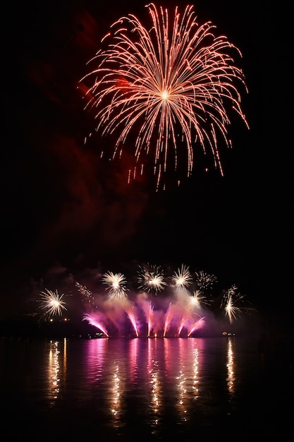 Fuegos artificiales coloridos reflejados en el agua