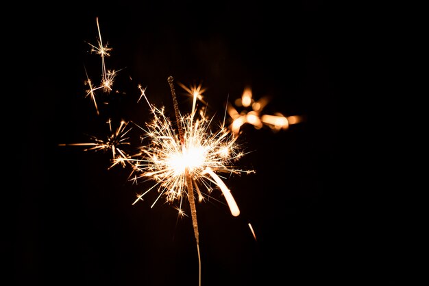 Fuegos artificiales dorados de ángulo bajo por la noche en el cielo