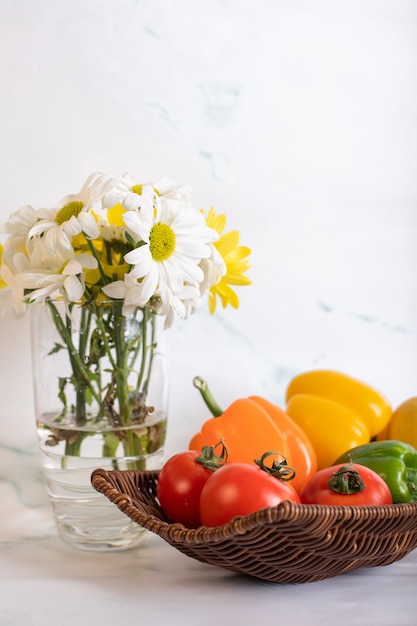 Fuente de tomate pimiento y un florero