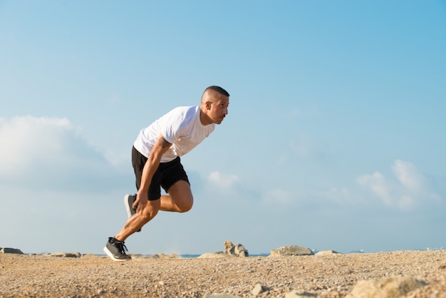 Fuerte atleta joven que comienza a correr al aire libre