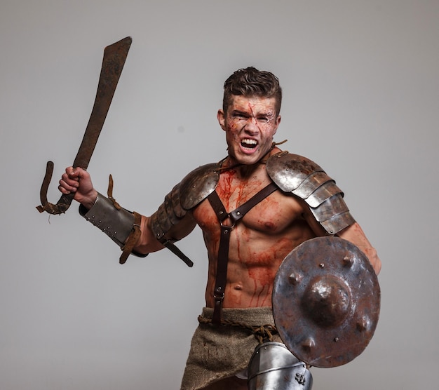 Foto gratuita fuertes ataques de gladiadores musculares con espada y escudo