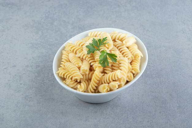 Fusilli casero sabroso en tazón de fuente blanco.