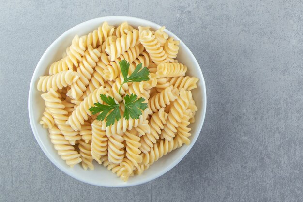 Fusilli casero sabroso en tazón de fuente blanco.