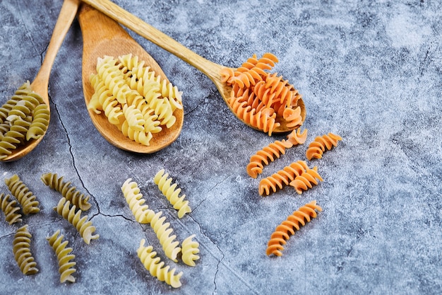 Foto gratuita fusilli crudo y cucharas de madera.