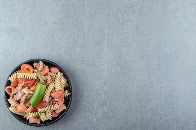 Fusilli hervido y pasta de conchas en un tazón negro