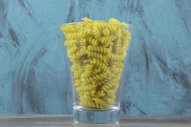 Foto gratuita fusilli verde seco en un tazón de vidrio.