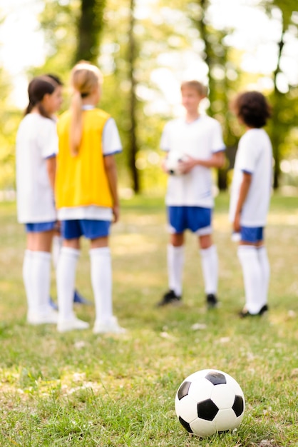 Fútbol en pasto junto a niños