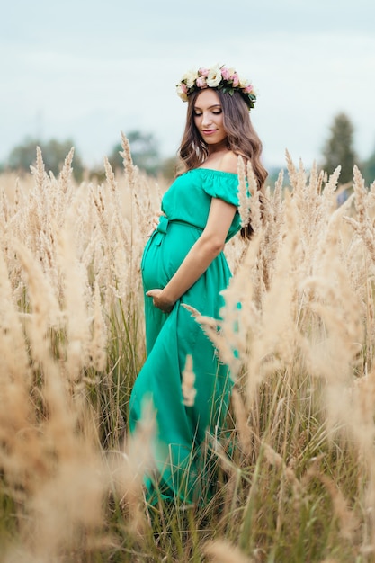 Foto gratuita la futura madre se para en la hierba