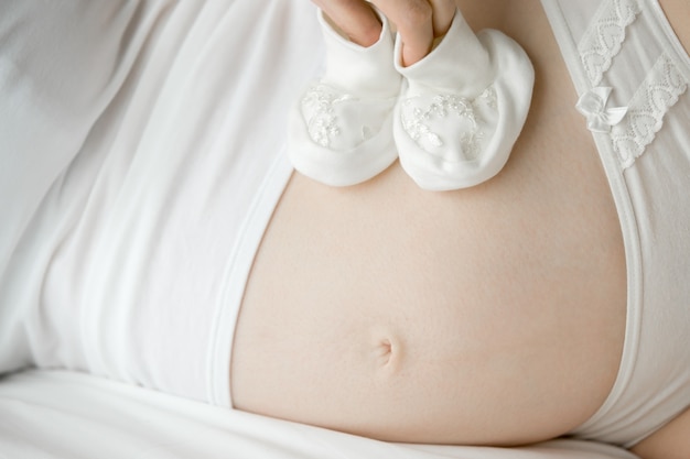 Foto gratuita futura madre con los patucos de su bebé