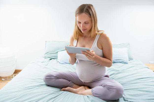 futura madre usando la aplicación en línea en tableta