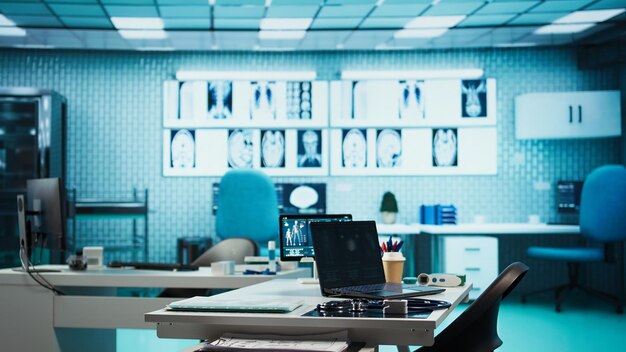 Gabinete médico vacío en una clínica privada con una computadora portátil y diagnósticos