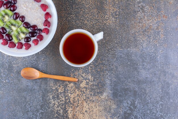 Gachas de avena lechosa con frutos rojos y una taza de té