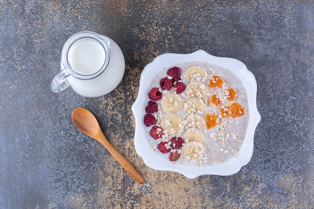 Foto gratuita gachas de muesli con frambuesas y un tarro de leche