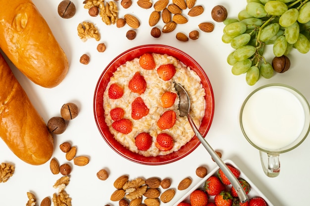 Gachas planas con frutas y nueces sobre fondo liso