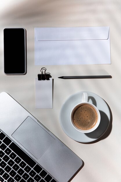 Gadgets, café, herramientas de trabajo en una mesa blanca en el interior.