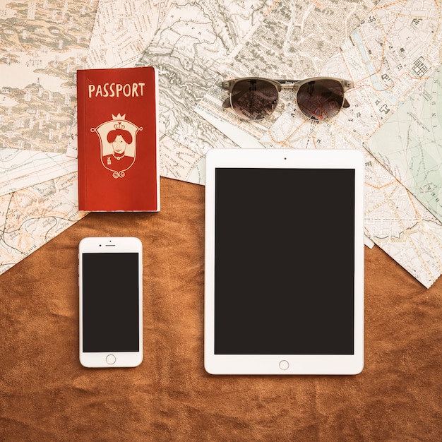 Foto gratuita gadgets con pasaporte y gafas de sol