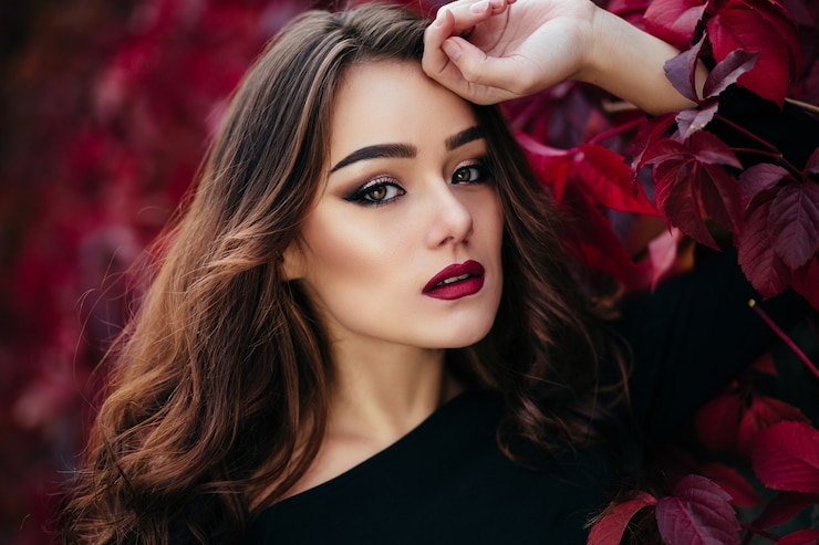 Photo Gratis gadis cantik itu berdiri di dekat dinding dengan dedaunan