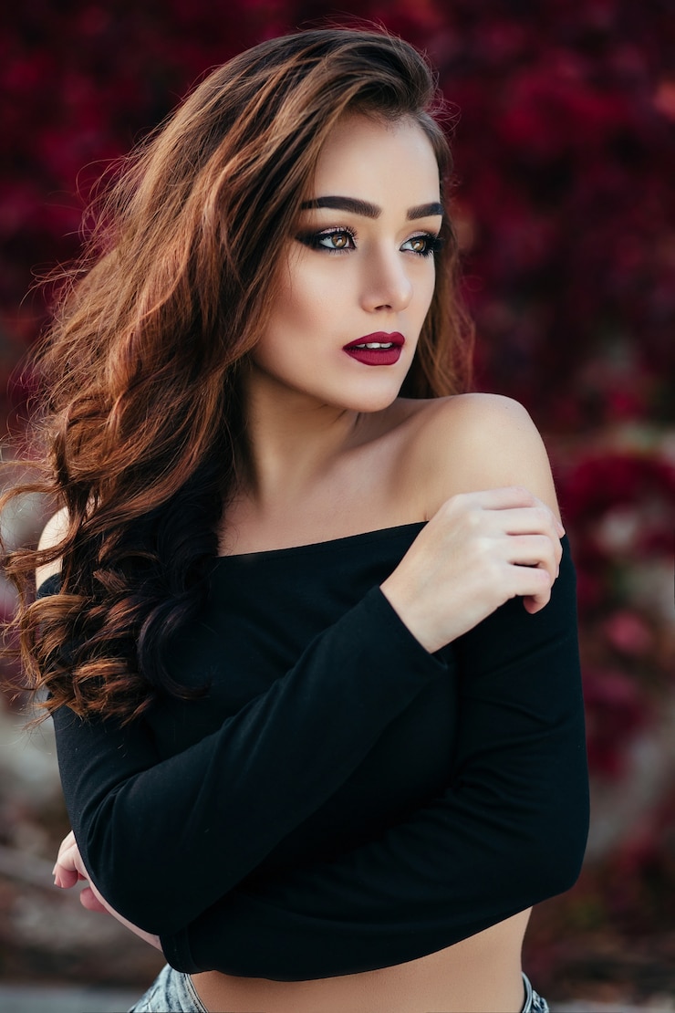 Photo Gratis gadis cantik itu berdiri di dekat dinding dengan dedaunan