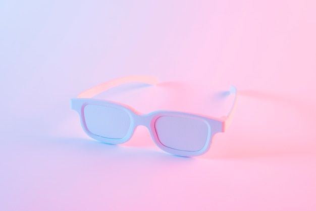 Foto gratuita gafas blancas contra el fondo rosa