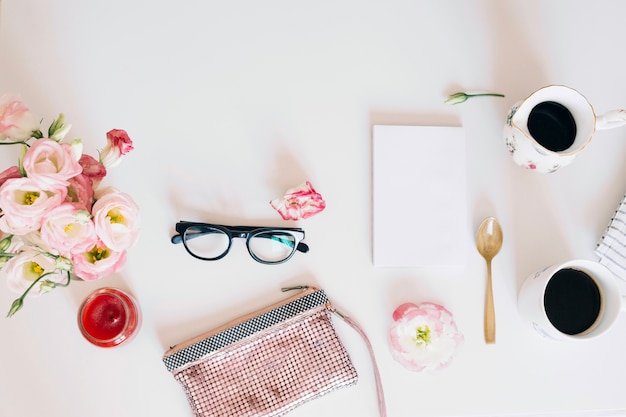 Gafas y bolso cerca de tazas de café