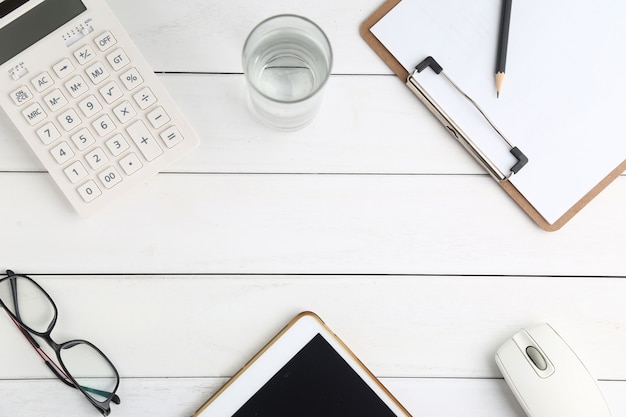 Foto gratuita gafas, calculadora y tableta en blanco escritorio aseado