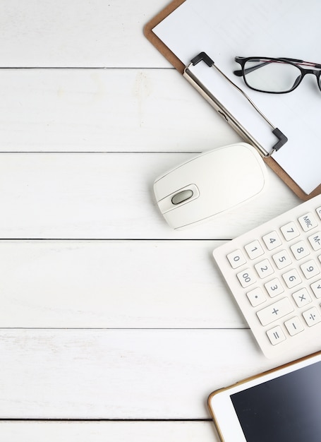 Gafas, calculadora y tableta en blanco escritorio aseado